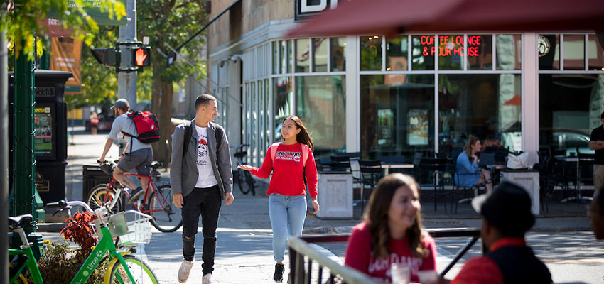 Students sit outside adjacent to Main Street Cortland