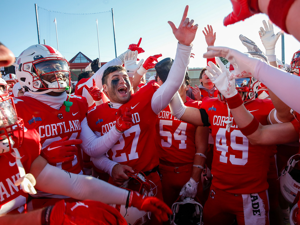 SUNY Cortland football team members celebrate at Grady Field.