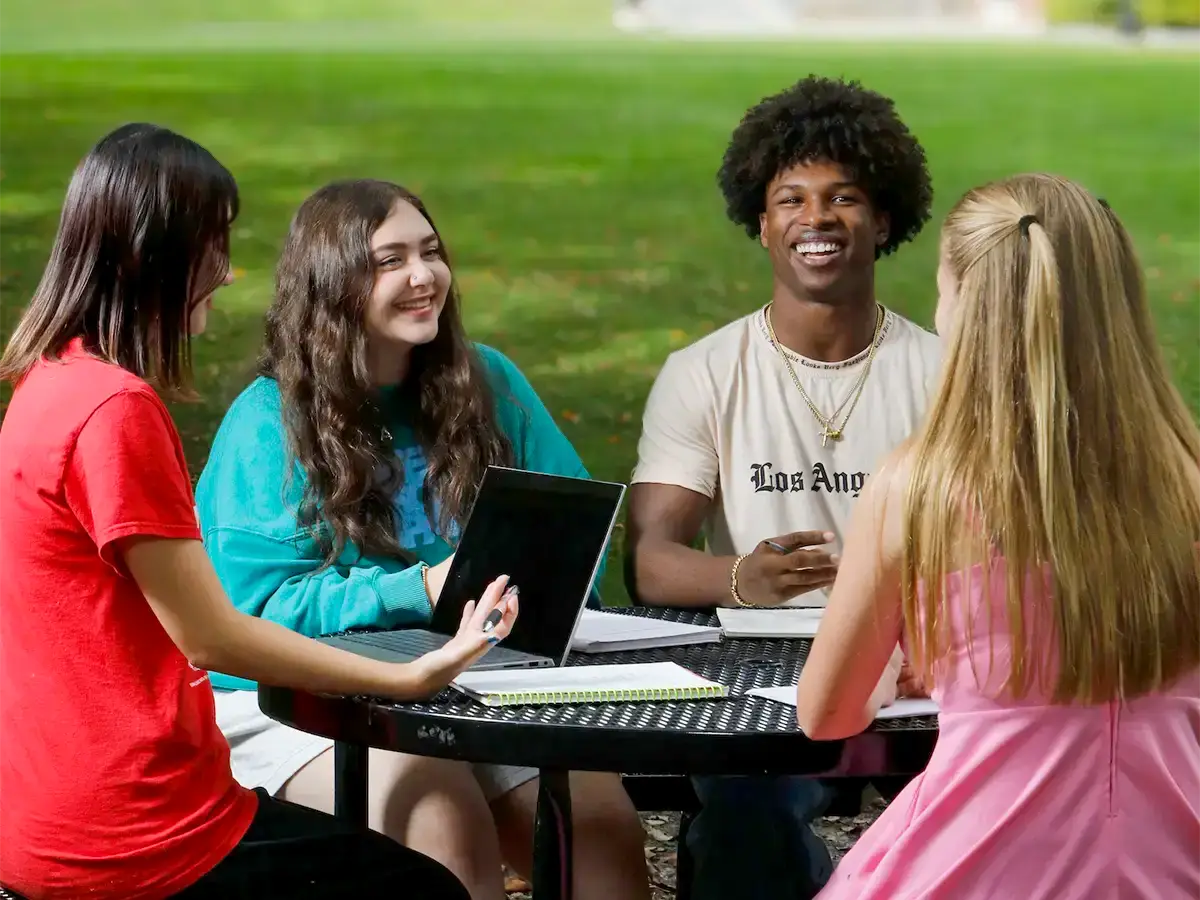 Students sitting around a table outside