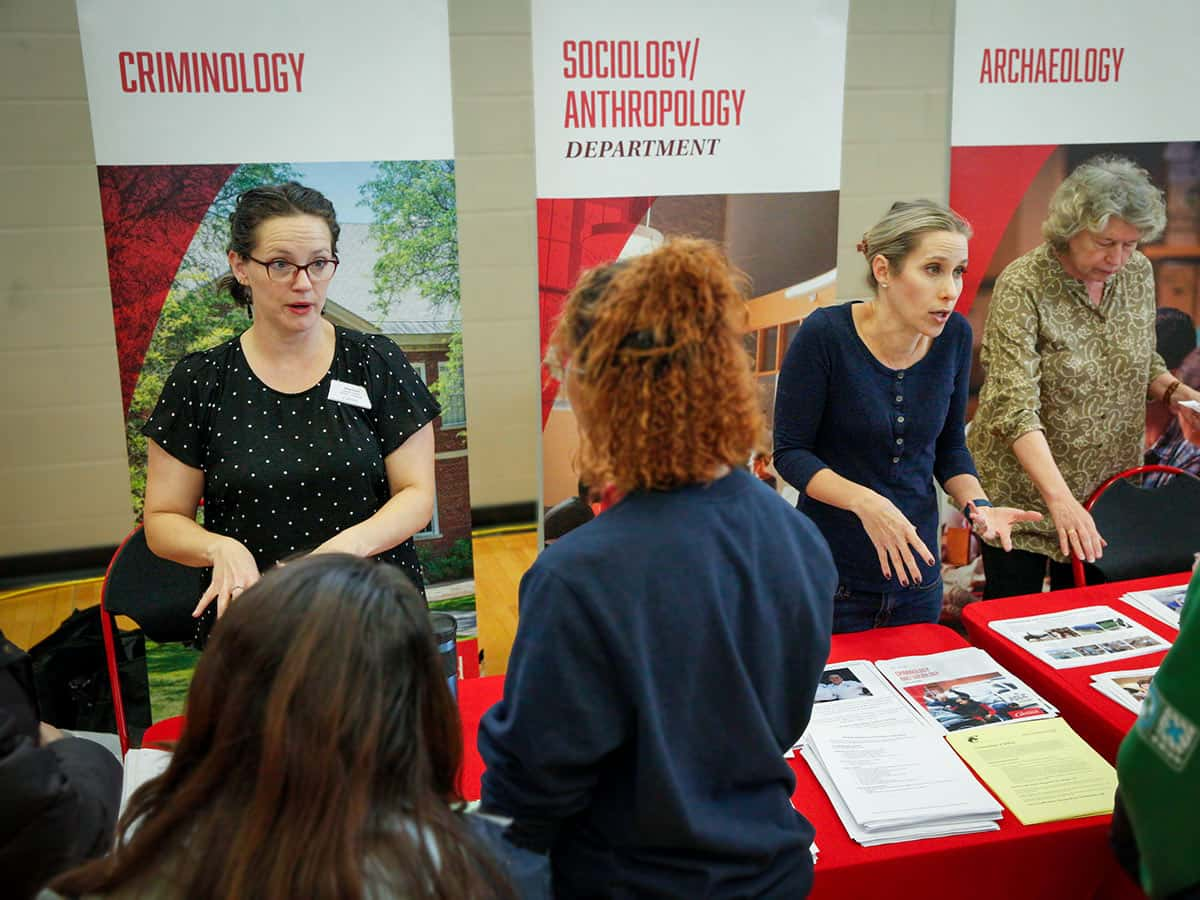 faculty members talking with perspective students and their families at Open House