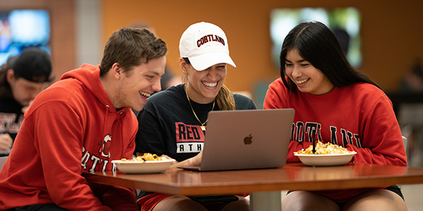 Three students looking at a computer together