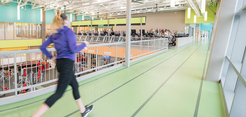 Student running on indoor 3 lane track