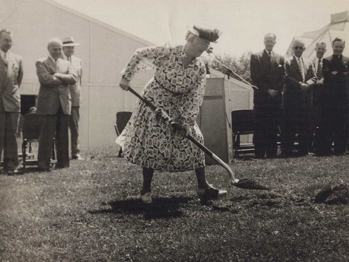 Historic black and white photo of Bessie Park with a shovel breaking ground on a new campus building.